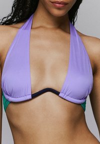 Paars en groen triangeldlijn bikini top van gladde stof, met een halternekontwerp en een contrasterende donkere rand langs de rand.