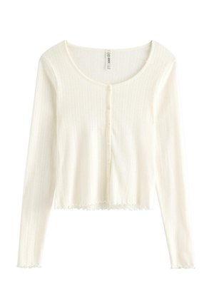 Top corto a maniche lunghe bianco a coste con scollo rotondo, chiusura con bottoni sul davanti e orlo smerlato.