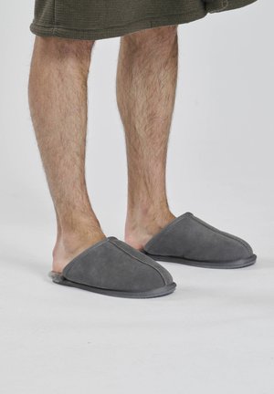 Graue Wildlederschuhe mit einem weichen Innenfutter, runder offener Zehenpartie und gestickten Details. Bequeme Konstruktion, geeignet für den Innenbereich.