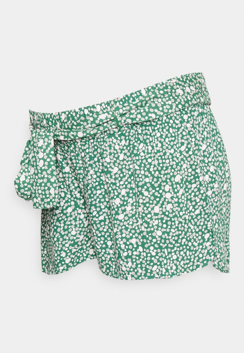 Shorts verts en tissu avec un motif à pois blancs, dotés d'une taille élastique et d'un détail de ceinture nouée.