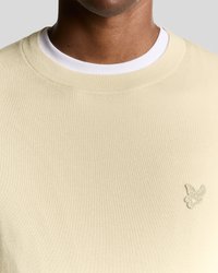 Φωτεινό μπεζ φούτερ με υφή υφάσματος, στρογγυλή λαιμόκοψη και λευκή εσωτερική γιακά. Διαθέτει μικρό κεντητό πεταλούδα στο στήθος.