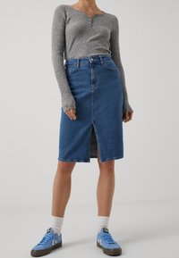 Väriin sininen farkkuhame, joka istuu vyötäröltä, edessä halkio ja helma ylettyy juuri polven alapuolelle. Yhdistetty harmaaseen ribbineulottuun pitkähihaiseen paitaan.