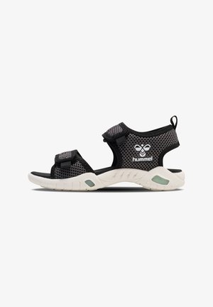 Black mesh sandals with adjustable straps, white sole, and textured footbed. Features a prominent logo on the side.