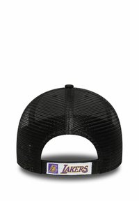 Svart nätbasebollkeps med rund form. Har en Lakers-logotyp på baksidan av remmen. Texturerat material och justerbar rem.