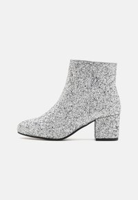 Botines de tobillo plateados con purpurina, con punta cuadrada y tacón bloque grueso, que cuentan con un acabado texturizado y un forro interior suave.