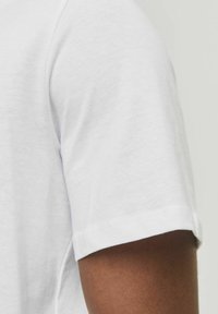 Witte T-shirt met korte mouwen en een zachte, gladde textuur. Heeft een klassieke ronde halslijn en een afgewerkte zoom, met een eenvoudig ontwerp.