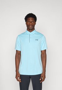 Lichtblauw poloshirt met een kraag en korte mouwen, gemaakt van ademende stof. Bevat een subtiel textuurpatroon en een zwart logo.