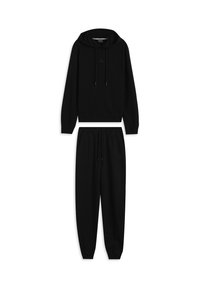 Sudadera negra con capucha, bolsillo frontal y cordones, combinada con pantalones jogger negros con cintura elástica y bolsillos laterales.