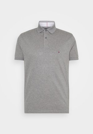 Polo gris à manches courtes avec patte de boutonnage à deux boutons et petit logo rectangulaire brodé sur la poitrine gauche.