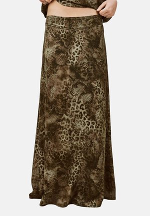 Jupe longue avec des motifs d'imprimés animaux mélangés dans des tons marron et noir sur une personne ajustant la taille.