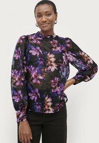 Schwarze transparente Bluse mit floralem Druck in Lila, Pink und Orange, hohem Kragen, Puffärmeln und Knopf-Akzenten an den Manschetten.