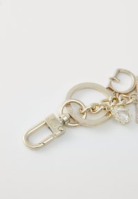 Gold-tone metal keychain featuring interlocking rings, a lobster clasp, and a teardrop crystal accent. Smooth texture and polished finish.