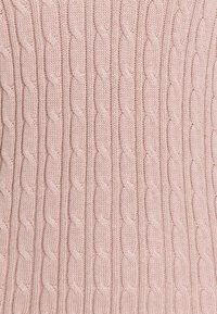 Roze gebreide stof met een kabelpatroon, gekenmerkt door textuurlussen met een verlengde vorm en ribbelsecties, wat zorgt voor een zachte, gezellige uitstraling.