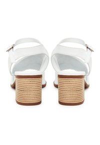 Weißes Leder-Absatzsandalen mit einem strukturierten, beige gefärbten Blockabsatz und verstellbarem Riemen. Das Innere ist weich mit minimalen Details.