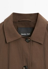 Brown collared coat with black buttons and "Massimo Dutti" label inside the neckline, made of smooth fabric.