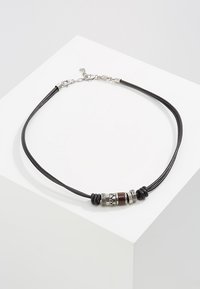 Schwarze Lederkette mit silberfarbenen Metallelementen, einer braunen Perle und gemusterten Metaldetails. Verstellbarer Verschluss für einen sicheren Sitz.