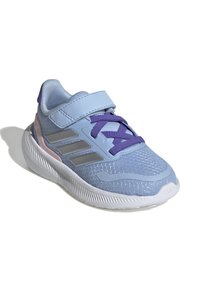 Baskets de sport bleu clair avec un dessus en maille, des accents violets, des rayures grises et une sangle Velcro. Elles disposent d'une semelle blanche en caoutchouc durable.