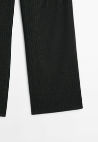 Pantalons noirs à rayures verticales en tissu lisse, présentant un design à jambes droites et une finition soignée, mettant en avant une texture et un motif subtils.