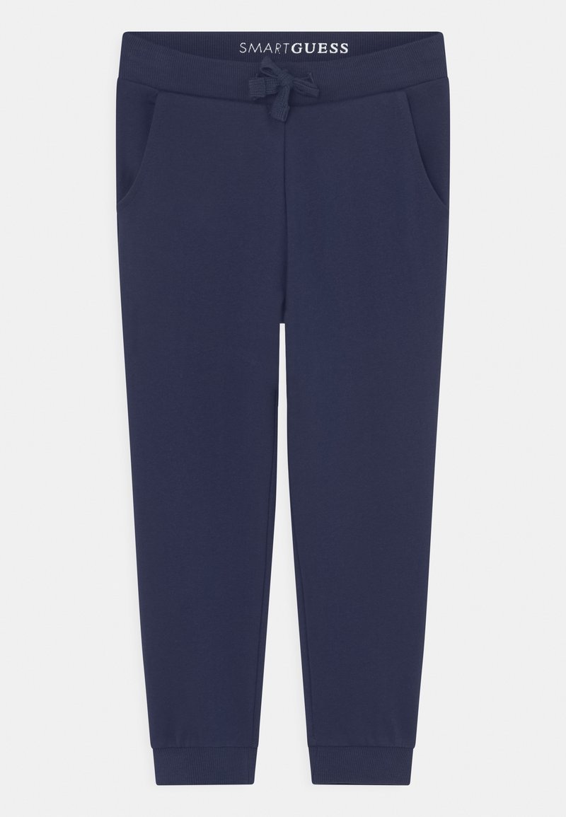 Pantalon de survêtement bleu marine avec poignets côtes, taille à cordon, poches latérales et logo "SMART GUESS" sur la ceinture.