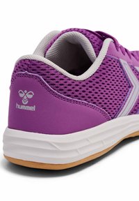 Fioletowy but sportowy z siateczkowatymi detalami, białymi akcentami, gumową podeszwą i logo na pięcie. Wyposażony w wyściełany kołnierz dla komfortu.