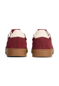 Rode suède sneakers met beige accenten en een gestructureerde rubberen zool. Voorzien van een gewatteerde kraag en hielpuller, met een klassiek atletisch ontwerp.