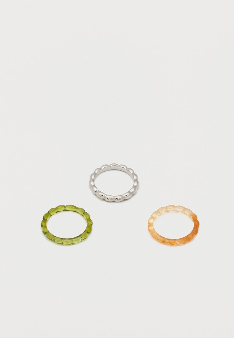 Τρία δαχτυλίδια με χάντρες σε ασημί, διαφανές πράσινο και διαφανές κεχριμπαρένιο, τοποθετημένα σε λευκό φόντο.
