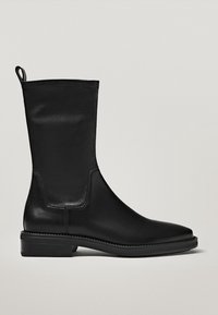 Bottines en cuir noir avec une texture lisse, un design épuré et un petit talon carré. Comprend une languette pour un enfilage facile.
