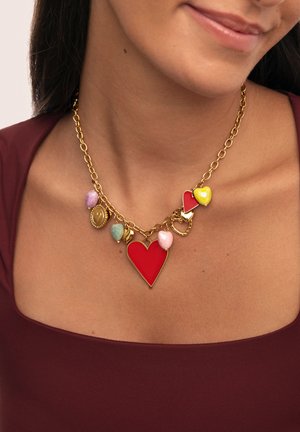 Collar de cadena de oro con un gran colgante en forma de corazón rojo, corazones de colores más pequeños en rosa, amarillo y verde, y otros charms decorativos.