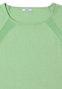 Haut en tricot vert clair avec encolure ronde et panneaux texturés sur les épaules, avec une petite étiquette blanche portant le texte "CECIL".