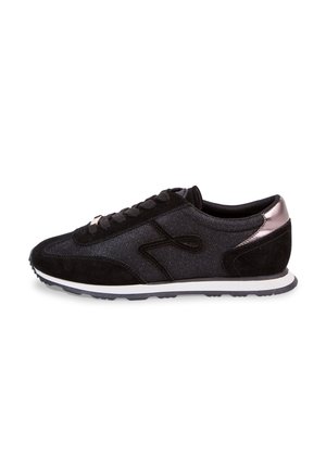 Zapatilla negra de caña baja con paneles de ante y tela, cordones negros, media suela blanca y detalle metálico en oro rosa en el talón.