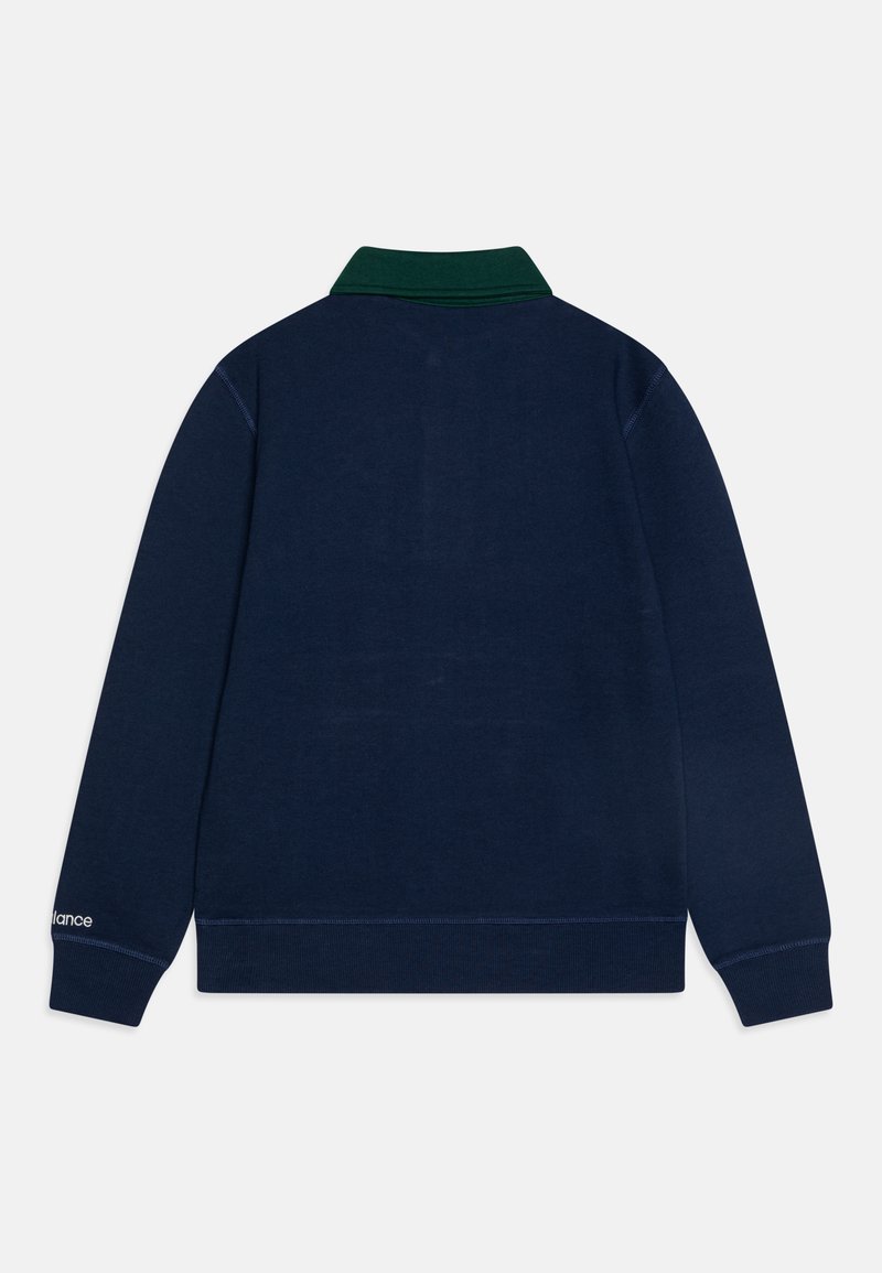 Navyblauwe polo met lange mouwen en een groene kraag. Bevat witte branding op de linker mouw en geribde manchetten en zoom. Soepele textuur.