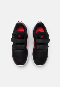 Baskets de sport noires avec tige en maille, accents roses et double bandes Velcro. Dotées d'une semelle intermédiaire blanche rembourrée pour plus de confort.