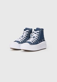 Sneakers alte in tela blu scuro con suole in gomma bianca. Presentano lacci bianchi e ricami a forma di stella sul lato. Elementi di design classici.
