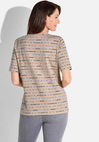 Beige korte mouw shirt met horizontale strepen in blauw en zwart, met een zachte textuur en een relaxte pasvorm. Accenten met subtiele details.