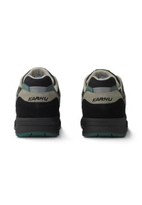 Mörkgrå och svarta sneakers i mocka och mesh, med gröna accenter, en vadderad sula och varumärkets logga på hälen.