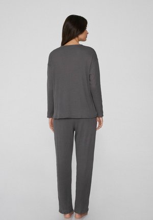 Grau langärmliges Oberteil und passende Hose aus einem weichen, strukturierten Stoff. Gerader Schnitt, lockere Passform mit einem subtilen Rippendesign.