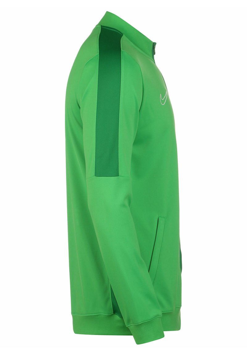 La chaqueta verde de Nike presenta un alto cuello, cierre con cremallera, paneles de hombro texturizados en verde y bolsillos laterales. Fabricada con un tejido suave y un diseño atlético.