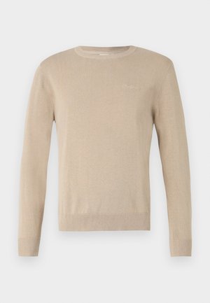 Beige sweater med rund hals, lange ærmer, ribbede manchetter og kant, lavet af et blødt, let materiale; har subtil branding på brystet.