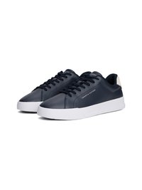 Sapatilhas de cano baixo azul marinho com solas brancas, atacadores pretos e a marca "Tommy Hilfiger" na lateral e na língua.