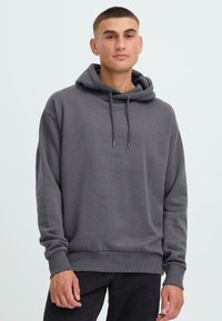 Grijze hoodie met een relaxte pasvorm, ribgebreide manchetten en onderrand, en trekkoorden bij de halsopening. Zachte, gestructureerde stof.