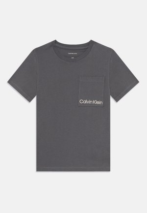 Gray cotton t-shirt with a crew neck, short sleeves, and a left chest pocket; features "Calvin Klein" logo in white embroidery.