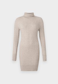 Vestido de punto beige con cuello alto y mangas largas, con detalles de botones en los puños y una silueta ajustada.