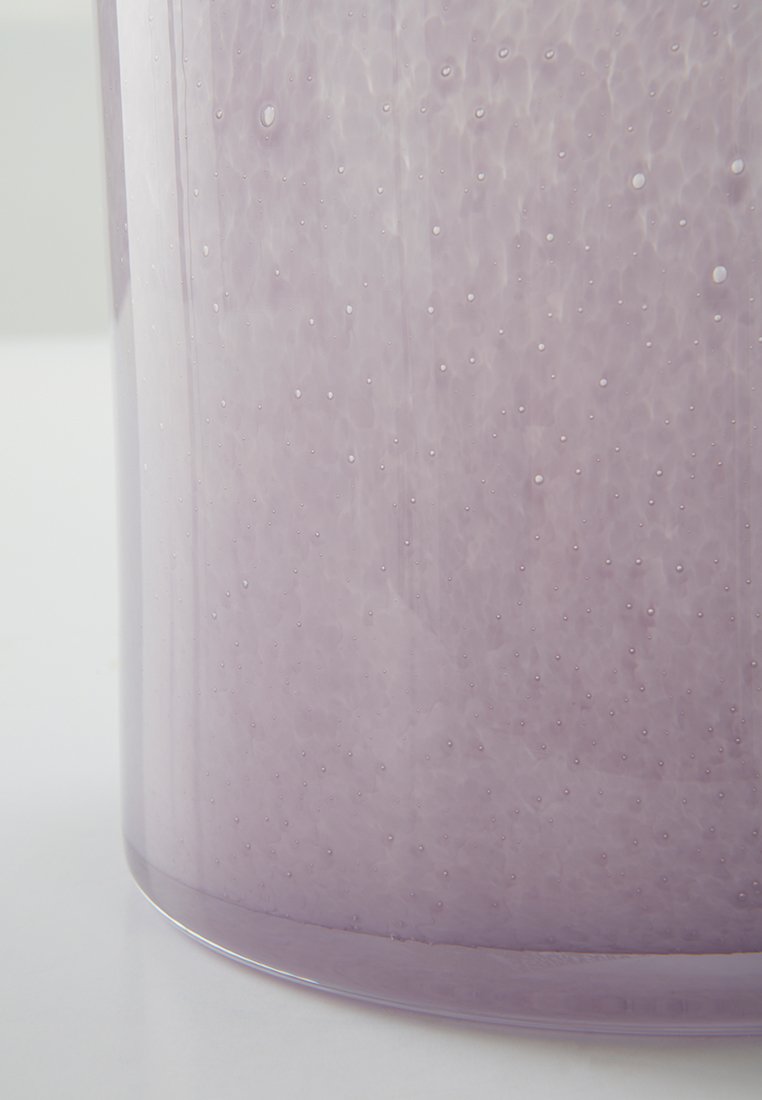Conteneur en verre translucide de couleur violet clair avec une surface texturée, comportant de petites bulles d'air pour un aspect unique. Bord inférieur arrondi.