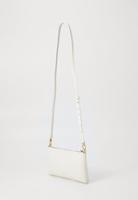 Witte leren crossbody tas met een vlakke rechthoekige vorm, verstelbare schouderband en goudkleurige hardware, met een subtiele logo-embossing aan de zijkant.