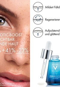 Vichy Mineral 89 Probiotic Fractions Serum in einer blauen Glasflasche mit einem Tropfenzähler. Klare Flüssigkeitstropfen auf der Oberfläche, mit einem silbernen Deckel.
