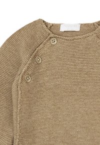 Beige stickad tröja med rund halsringning, utrustad med tre bruna knappar på axeln och texturerat tyg för extra detalj.