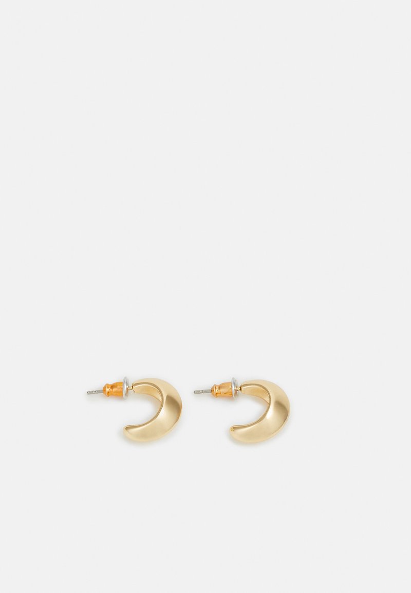 Guldhalvmåneformade örhängen med en slät yta, med orange detaljer nära fästet och silverfärgad hårdvara.