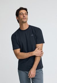 Schwarz, kurzärmliges T-Shirt aus Baumwolle mit einem strukturierten quadratischen Patch und dem Schriftzug "POLO CLUB" auf der linken Brust. Glatte Stoffqualität.