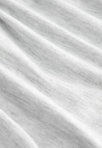 Tessuto grigio chiaro con una texture morbida e liscia, caratterizzato da sottili variazioni di colore e un motivo finemente intrecciato. Caduta fluida e leggero.