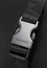 Schwarzer Nylon-Gurt mit einer mattschwarzen Plastikschnalle und dem Logo "BOGNER". Strukturierter Gurt für besseren Halt und Langlebigkeit.